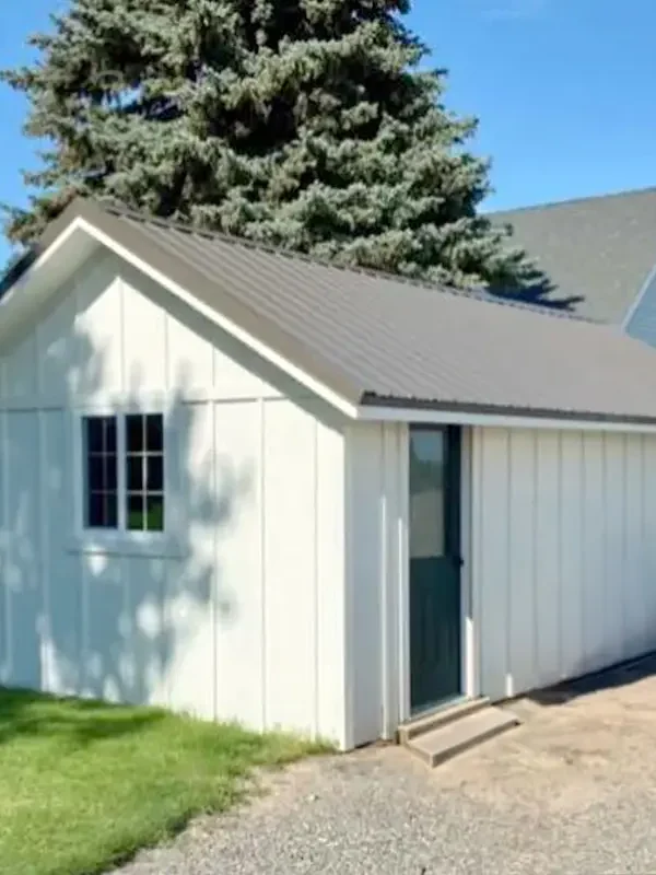 The after photo of a building remodel with white board and batten siding.